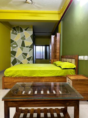 een slaapkamer met een bed en een tafel. bij VALIYAVEETTIL INN in Irikkūr