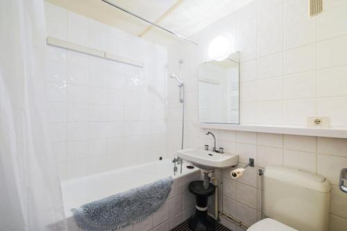 une salle de bain blanche avec un lavabo et une baignoire dans l'établissement Résidence Aldébaran - maeva Home - Appartement 3 Pièces 8 Personnes - Confort MAE-4231, à Arâches-la-Frasse