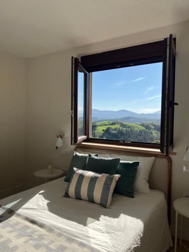 a bed with a large window in a bedroom at Mirando a Corona in Ayuela