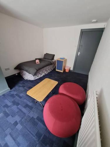 una camera con un letto e uno sgabello rosso di Room near East Midland Airport Room 7 a Kegworth
