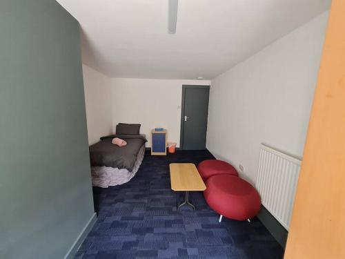 1 dormitorio con cama, mesa y banco en Room near East Midland Airport 7 en Kegworth