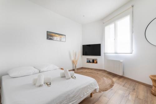 - une chambre blanche avec un lit blanc et une télévision dans l'établissement Appartement Blanqui - Welkeys, à La Seyne-sur-Mer