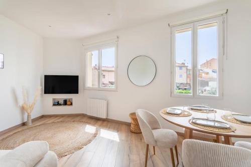 a white living room with a table and chairs at Appartement Blanqui - Welkeys in La Seyne-sur-Mer