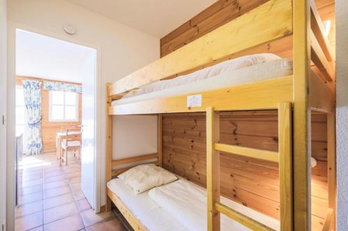 Ce dortoir comprend 2 lits superposés et une table. dans l'établissement Résidence Le Château de Crans - maeva Home - Studio 4 personnes - Confort MAE-4250, à Flaine