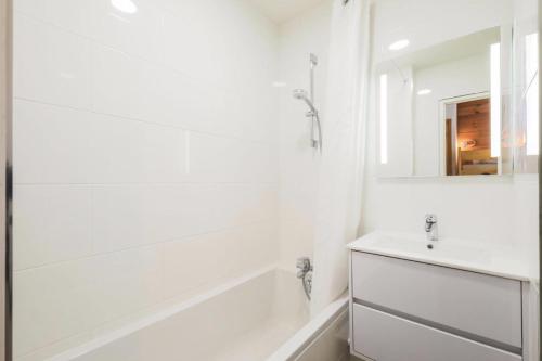une salle de bain blanche avec une baignoire et un lavabo dans l'établissement Résidence Le Château de Crans - maeva Home - Studio 4 personnes - Confort MAE-4250, à Flaine