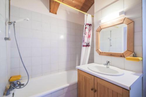 une salle de bain avec un lavabo, une baignoire et un miroir dans l'établissement Résidence Le Château de Crans - maeva Home - Appartement 3 Pièces 10 Personnes - Budget MAE-4252, à Flaine