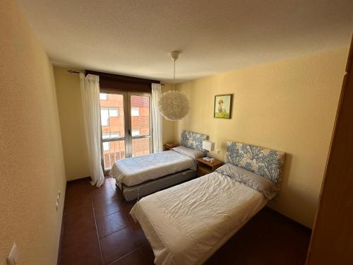 mały pokój z 2 łóżkami i oknem w obiekcie PLAYA DE SAN VICENTE DE LA BARQUERA w mieście San Vicente de la Barquera