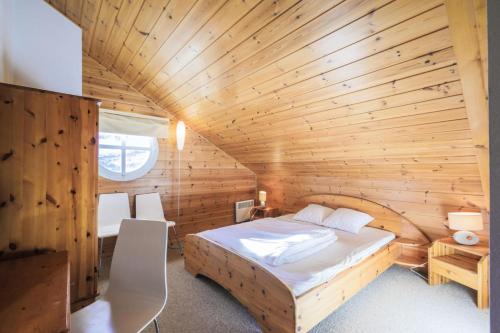 une chambre avec un lit dans une cabane en bois dans l'établissement Résidence Le Château de Crans - maeva Home - Appartement 5 pièces 10 personnes avec sauna privé - Prestige MAE-4441, à Flaine