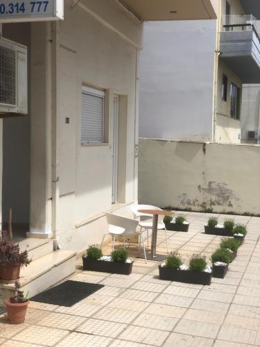 a patio with a bench and a table and plants at Chrysa- Kyra Apartments in Heraklio Town