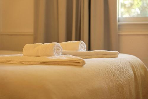 a bed with white towels on top of it at Baden Baden Carilo in Carilo