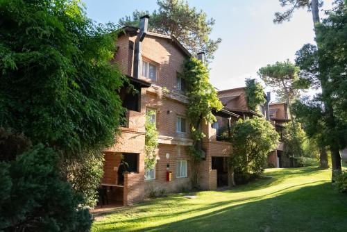 an old brick house with trees in front of it at Baden Baden Carilo in Carilo