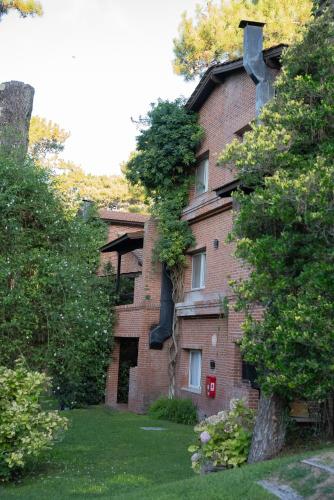 a large brick building with trees in front of it at Baden Baden Carilo in Carilo