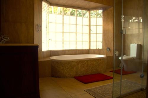 a bathroom with a bath tub and a window at 9 Spitfire in Benoni