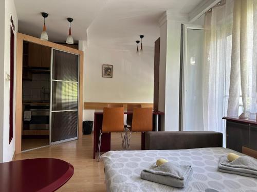 a bedroom with a bed and a dining room at Skopje Plaza Apartment in Skopje