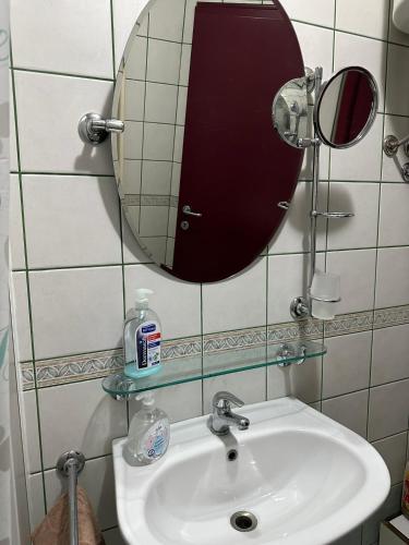 a bathroom with a sink and a mirror at Skopje Plaza Apartment in Skopje