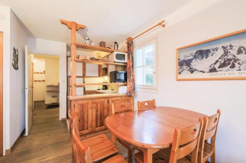 une cuisine et une salle à manger avec une table et des chaises en bois dans l'établissement Résidence Arbaron - maeva Home - Appartement 3 Pièces 8 Personnes - Budget MAE-4591, à Flaine