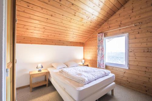 une chambre avec un lit dans une pièce en bois dans l'établissement Résidence Arbaron - maeva Home - Appartement 3 Pièces 8 Personnes - Budget MAE-4591, à Flaine