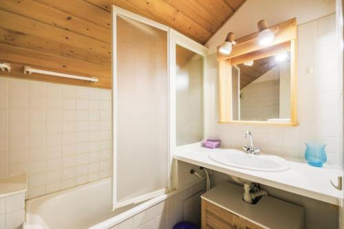 une salle de bain avec un lavabo et un miroir dans l'établissement Résidence Arbaron - maeva Home - Appartement 3 Pièces 8 Personnes - Budget MAE-4591, à Flaine
