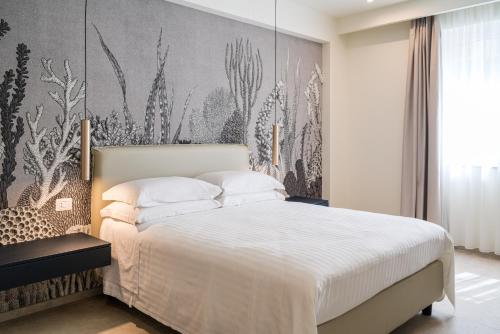 a bedroom with a large bed with a wall mural at I Due Mori - Luxury Rooms in Giardini Naxos