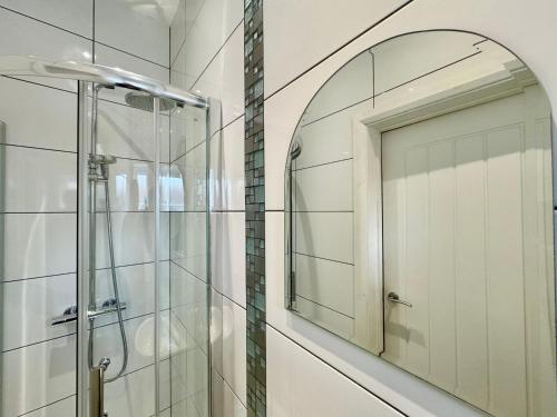 La salle de bains est pourvue d'un miroir et d'une douche. dans l'établissement Limpenny Studio - Cityscape Cozy Corner, à Nottingham