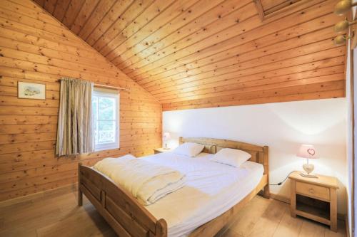 Ce lit se trouve dans un dortoir doté d'un plafond en bois. dans l'établissement Résidence Arbaron - maeva Home - Appartement Pièces - Sélection 95, à Flaine