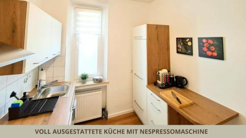 a kitchen with a sink and a refrigerator at FeWo Markgrafenrefugium zentrumsnahe 2 Zi mit Küche für 1-4 Personen in Bayreuth
