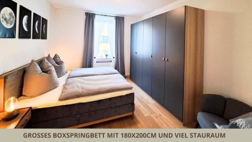 a bedroom with a large bed and a cabinet at FeWo Markgrafenrefugium zentrumsnahe 2 Zi mit Küche für 1-4 Personen in Bayreuth
