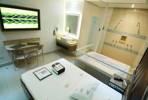Habitación hospitalaria con cama, lavabo y bañera en Motel Fashion ABC 5, en Santo André