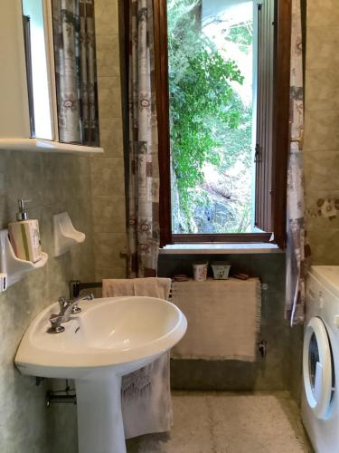 een badkamer met een wastafel en een raam bij Casa Piaghen in Pai