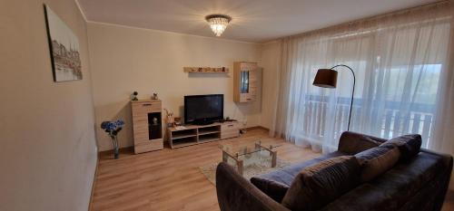 een woonkamer met een bank en een televisie bij Сozy Apartment In Great Location in Rīga