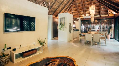 a living room with a table and a dining room at Orchid House Tulum Jungle in Tulum