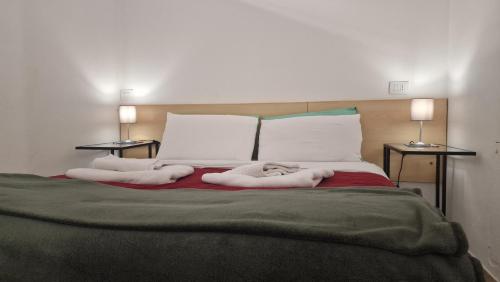 sypialnia z łóżkiem z białą pościelą i poduszkami w obiekcie Fiorilli House - Fair District - Gratis Private Parking w Bolonii