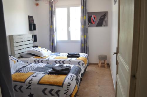 2 Einzelbetten in einem Zimmer mit Fenster in der Unterkunft Gîte en Provence in Monteux