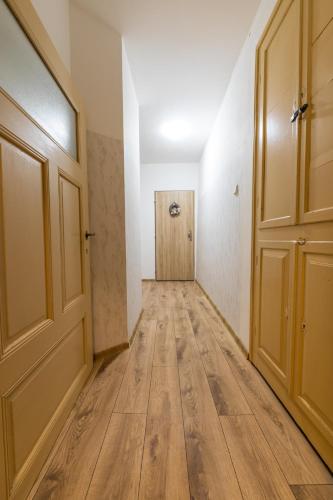 an empty hallway with a door and wooden floors at Ubytování v centru in Lanškroun