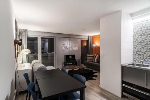 Una cocina y una sala de estar con mesa y sillas. en Résidence La Petite Ourse - maeva Home - Studio 3 Personnes - Sélection MAE-4901, en Arâches-la-Frasse