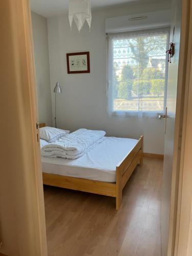 - une petite chambre avec un lit et une fenêtre dans l'établissement Sainte-Marine, Appartement cosy rez-de-jardin à 150m de la plage, à Combrit