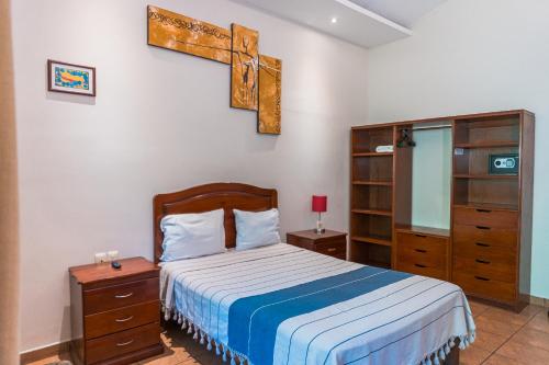 a bedroom with a bed and a cross on the wall at Hotel Don Nino in Oaxaca City