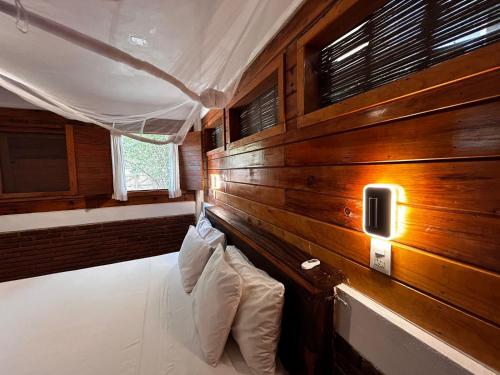 a room with a wooden wall with pillows at Casa Gaviota in Mazunte