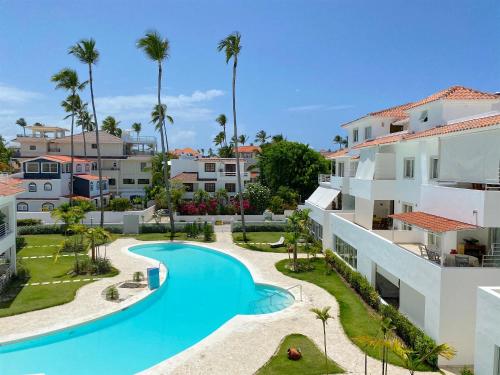 vista sulla piscina di un resort con palme di LOS CORALES VILLAS and SUITES - BEACH CLUB, SPA, RESTAURANTS a Punta Cana