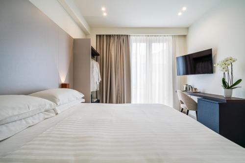 a hotel room with a large bed and a desk at I Due Mori - Luxury Rooms in Giardini Naxos