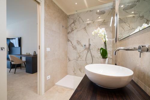 a bathroom with a white tub and a sink at I Due Mori - Luxury Rooms in Giardini Naxos