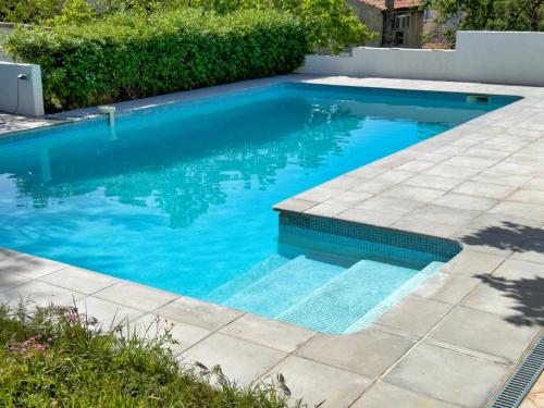 uma piscina com água azul em um quintal em Maison de Charme Classée 3 étoiles - Calme, Jardin, Salle de Sport, Piscine em Marselha