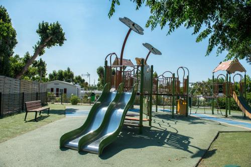 a playground with a slide in a park at Mobil home les sables du midi 4 étoiles in Valras-Plage