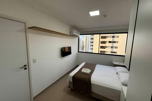 a bedroom with a bed and a large window at Hosts BR-Flat Fit Transamérica Boa Viagem s/ taxa in Recife