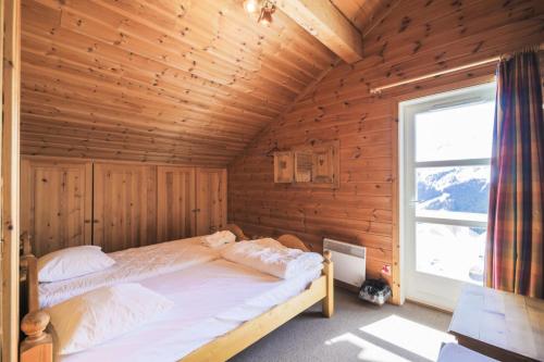 une chambre avec un lit dans une pièce en bois dans l'établissement Les Chalets de Flaine Hameau - maeva Home - Chalet 7 Pièces 12 Personnes - Sélection MAE-7441, à Flaine