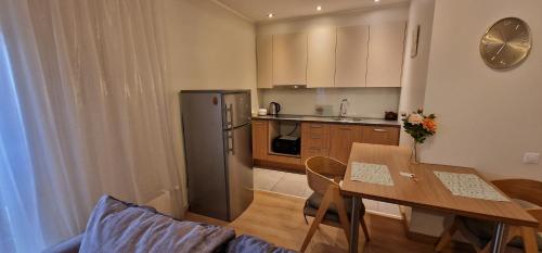a kitchen with a table and a kitchen with a refrigerator at Сozy Apartment In Great Location in Rīga