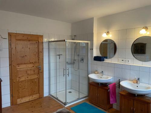 uma casa de banho com 2 lavatórios, um chuveiro e 2 espelhos em Reiterhof em Lemgo