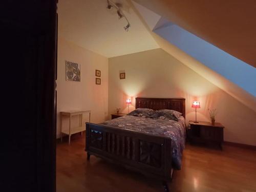 默爾索爾的住宿－LA CONFRERIE à MEURSAULT au CŒUR DE LA BOURGOGNE，一间位于阁楼的卧室,配有一张床和两盏灯。