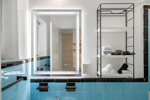 a bathroom with a large mirror and blue tiles at Studios On 25th by BCA Furnished Apartments in Atlanta