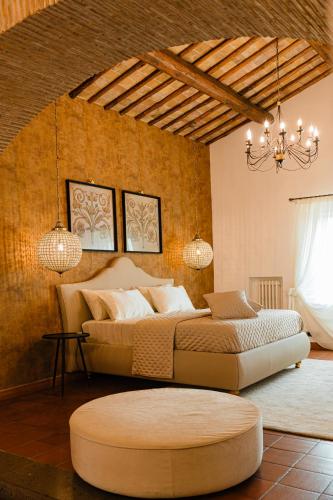 ein Schlafzimmer mit einem großen Bett und einem Kronleuchter in der Unterkunft Suite Casale Campovecchio in Grottaferrata